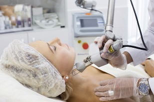 Cosmetologist rejuvenates skin with laser